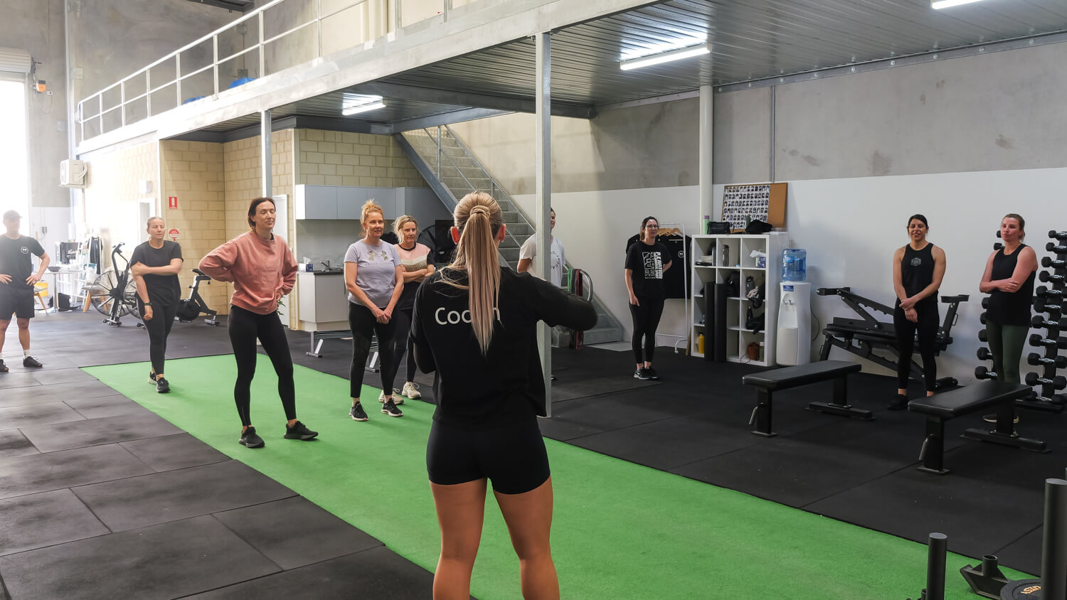 Coach instructing a small group class through todays workout